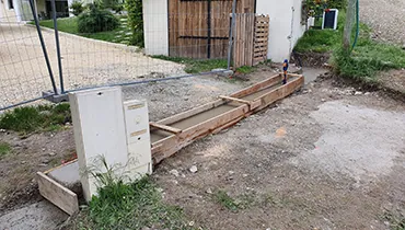 Fondations préparées avant la pose d’une clôture