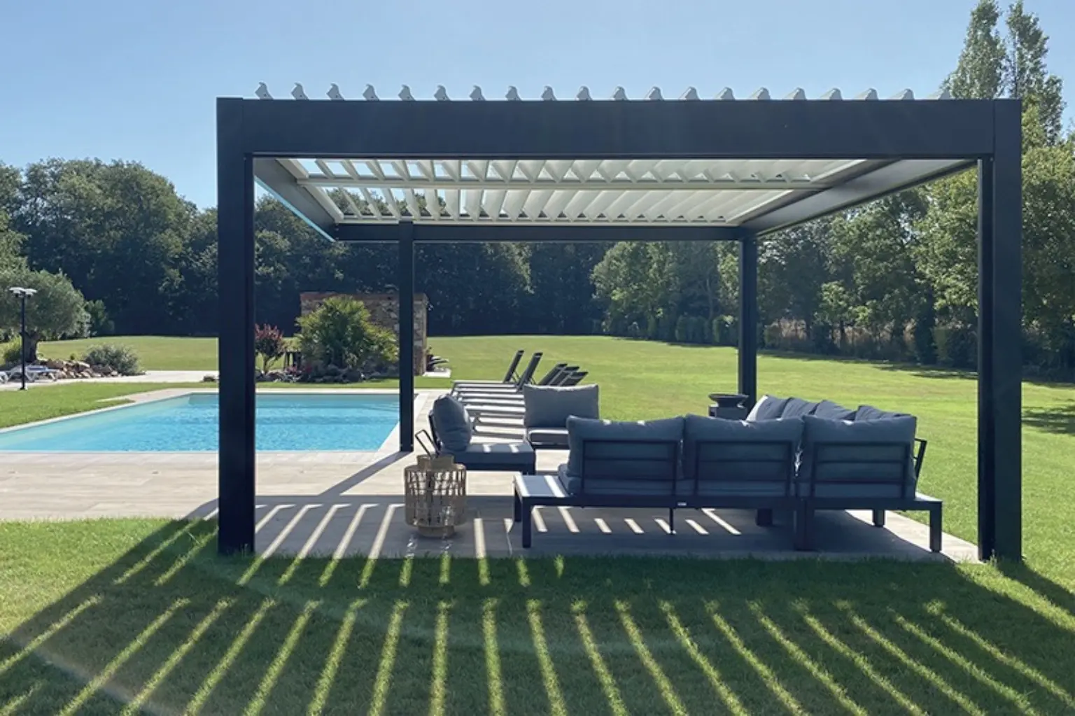 Pergola bioclimatique autoportée anthracite installée près d’une piscine