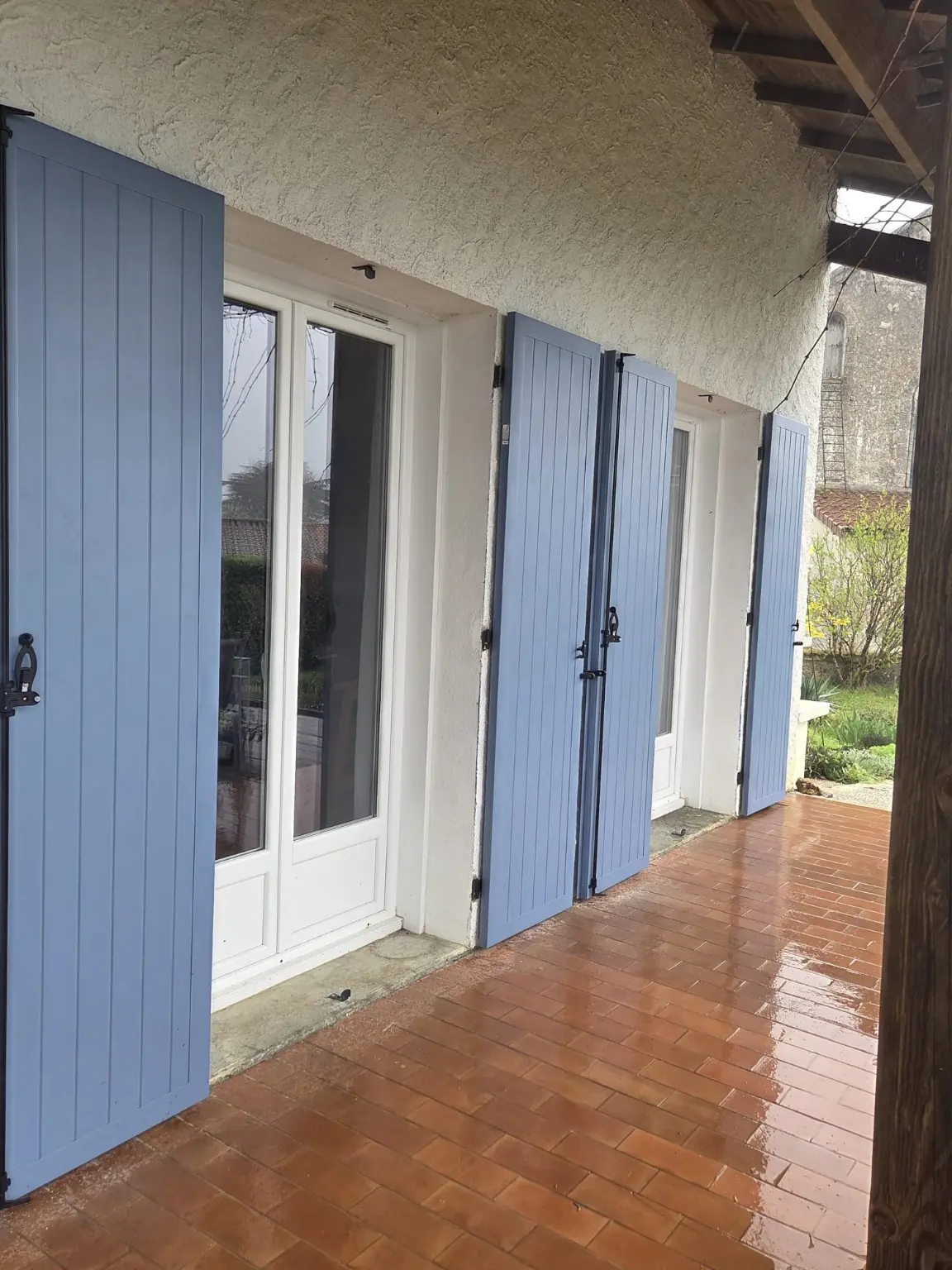 Série de volets battants aluminium bleus posés sur plusieurs ouvertures